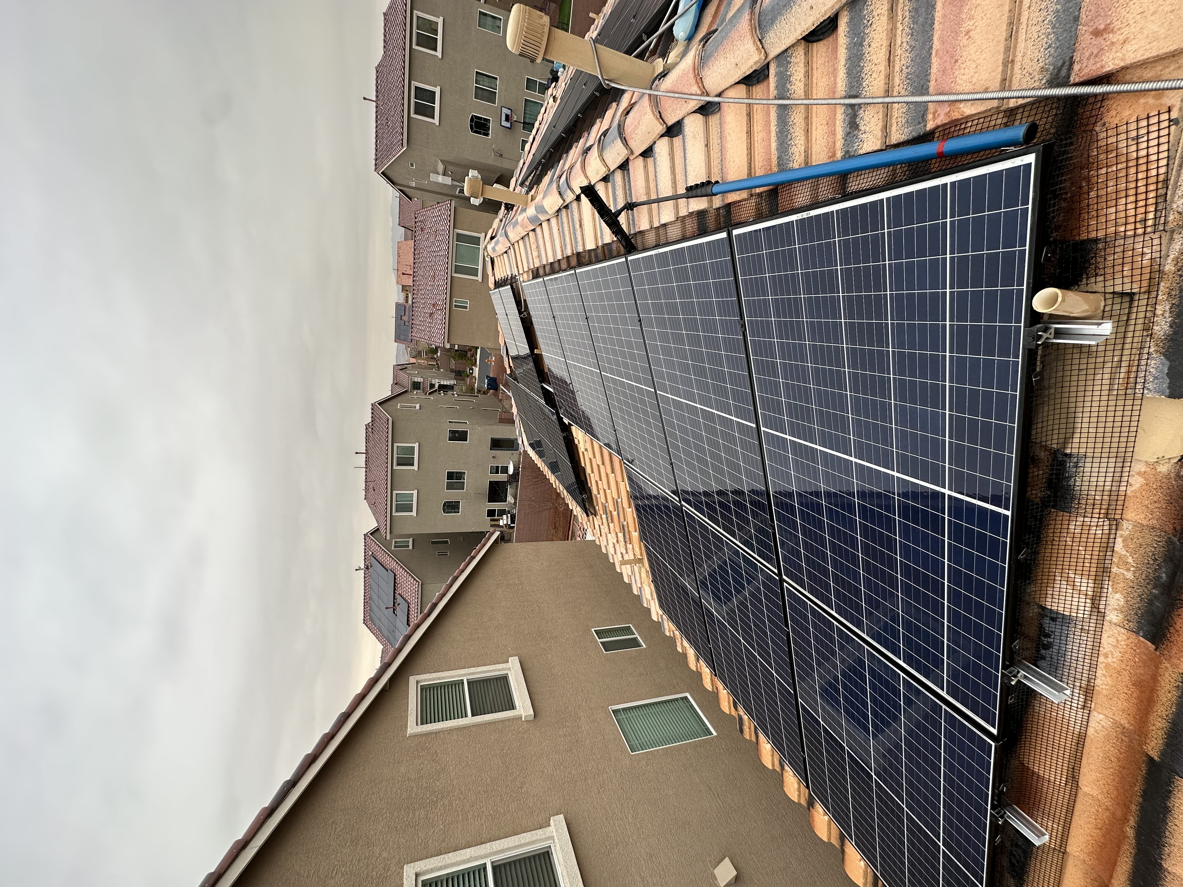 Tile-roof rooftop solar array in Henderson Nevada being cleaned with water-fed pole